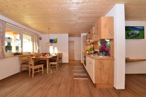 a kitchen and dining room with a wooden ceiling at Landhof Müller in Wertach