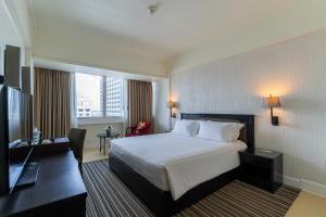 a hotel room with a bed and a television at Centara Hotel Hat Yai in Hat Yai