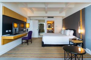 a hotel room with a large bed and a desk at Centara Hotel Hat Yai in Hat Yai