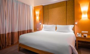a bedroom with a large bed with two pillows at Centara Hotel Hat Yai in Hat Yai +61 photos