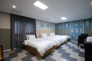 two beds in a room with blue walls at Hotel Mondavi in Mokpo