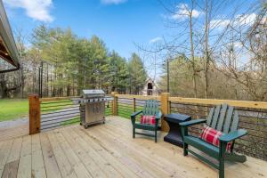 two chairs and a grill on a wooden deck at Family fun, romantic Hot Tub, Firepit, King Bed 15 min from Blue Ridge & Ellijay in Blue Ridge