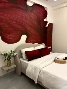 a bedroom with a bed with a red painting on the wall at Chèrie Blueleaf in Jaipur