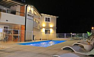 a swimming pool in front of a building at night at Complejo Bienteveo in San Antonio de Arredondo