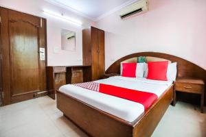 a bedroom with a large bed with red pillows at Hotel O by OYO Angad Continental in Ambāla
