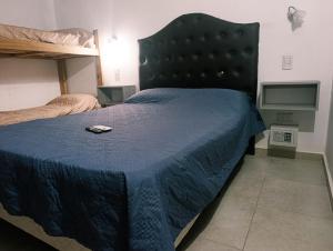a bedroom with a bed with a cell phone on it at Complejo Bienteveo in San Antonio de Arredondo