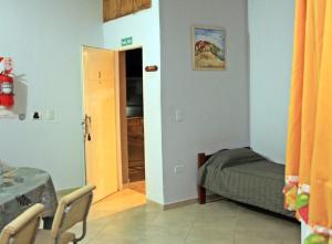 a small bedroom with a bed and a door at Complejo Bienteveo in San Antonio de Arredondo