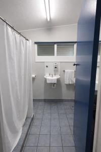 a bathroom with a sink and a shower curtain at Zen Hostel in Townsville