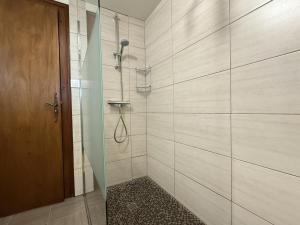 a bathroom with a shower with a glass door at Ordokia in Lasse +18 photos