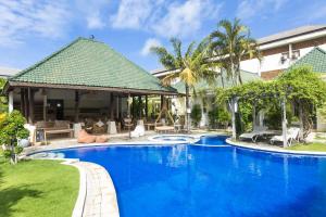 a swimming pool in front of a villa at Artemis Villa Hotel in Seminyak