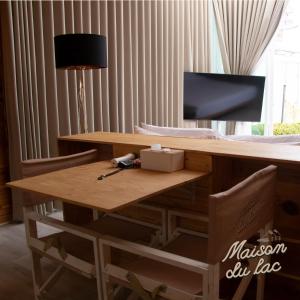 a wooden table with two chairs and a lamp at Maison Du Lac The Panoramic Glass Lodge in Wang Nam Khieo