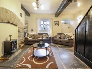 a living room with couches and a fireplace at Cynfal Fawr in Blaenau-Ffestiniog
