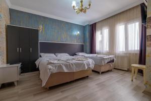 a bedroom with two beds and a chandelier at suites beyazıt in Istanbul