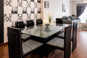 a dining room with a glass table and chairs at Arabella Residence 2BR - New Cairo Luxury Stay in Cairo