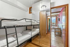 a room with two bunk beds and a mirror at Studio Valleverde 26B - Happy Rentals in Sestriere