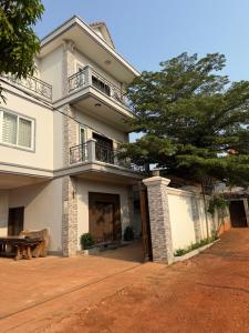 a white house with a tree in front of it at Thida Villa in Siem Reap