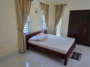 a bedroom with a bed with two pillows on it at Thida Villa in Siem Reap