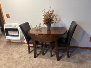 a wooden table with black chairs and a vase with flowers at The Loft on the Lot in Cambridge