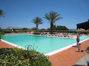 a man and a child playing in a swimming pool at Residence Liscia Eldi in San Teodoro