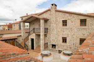 a large stone building with stairs in front of it at La Tahona Vieja in El Barraco