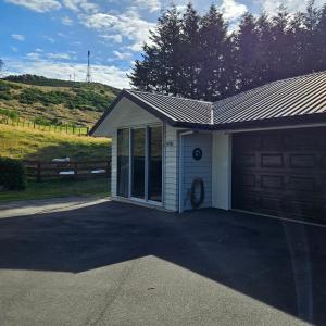 a garage next to a house with a driveway at Seventy-Four on Ramsay in Taupo