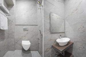 a white bathroom with a sink and a toilet at Super Townhouse DSIDC Bawana Formerly Kanhaiya Residency in Delhi