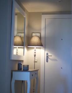 a room with a lamp and a table with a mirror at Apartamentos Santa Clara in Calpe
