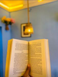 eine Person, die ein Buch in der Hand hält in der Unterkunft Satori Capsule Hotel in Dhulikhel