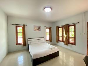 a bedroom with a bed in a room with windows at Thip Thip Ressort Ao Nang in Ban Khlong Haeng