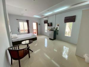 a large room with a bed and a table and a chair at Thip Thip Ressort Ao Nang in Ban Khlong Haeng