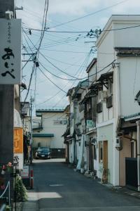 an alley with a car driving down a street at 灯GuestHouse in Aizuwakamatsu