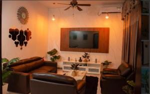 a living room with two leather couches and a television at Sunset Private Villa in Bandara