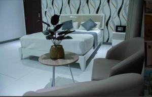 a bedroom with a bed and a table with a plant at Sunset Private Villa in Bandara