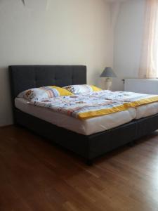 ein großes Bett in einem Zimmer mit Holzboden in der Unterkunft Ferienwohnung in Krems-Stein/Donau in Krems an der Donau