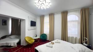 a hotel room with two beds and a yellow chair at Hotel Zava Boutique - City Center in Bucharest