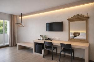 a room with a desk with two chairs and a mirror at Smile Bed Hotel in Sathani Khlong Rian