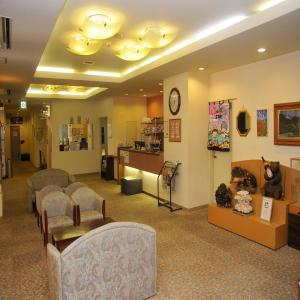 a waiting area with chairs and a waiting room with a clock at Yumoto Ginsenkaku in Kamikawa +51 photos