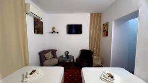 a hotel room with two beds and a tv at Hotel Zava Boutique - City Center in Bucharest