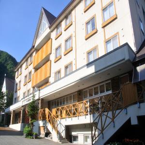 a large white building with a balcony at Yumoto Ginsenkaku in Kamikawa