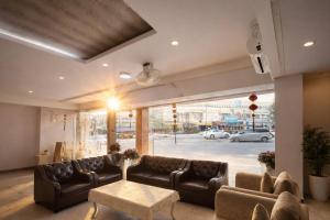 a lobby with leather couches and a table at Smile Bed Hotel in Sathani Khlong Rian