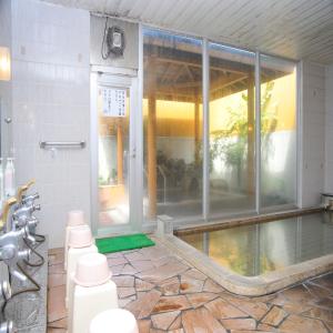 baño con piscina y ducha en Yumoto Ginsenkaku, en Kamikawa
