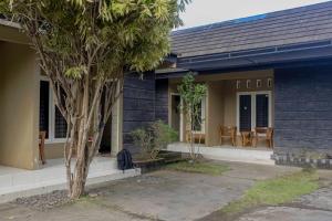 a blue house with a tree in front of it at Sandik Local Stay in Midang +9 photos