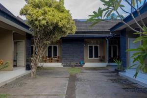 a blue house with a tree in front of it at Sandik Local Stay in Midang