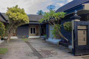 a blue house with trees in front of it at Sandik Local Stay in Midang