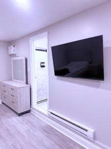 a living room with a large flat screen tv on the wall at Entire Private Studio JFK in Morris Park
