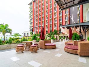 a patio with wicker chairs and tables and umbrellas at Cebu Serene Quarters with City View in Mactan Island
