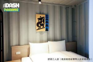 a bedroom with a bed and a sign on the wall at Dash Forwaves Hotel in Toucheng