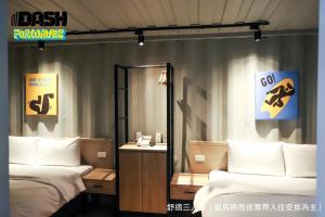 a room with two beds and a desk with a mirror at Dash Forwaves Hotel in Toucheng