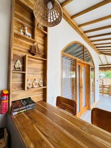 a room with wooden walls and a large window at The Lauk private in Gili Islands