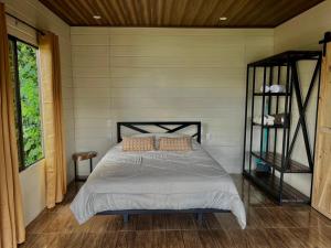 a bedroom with a bed in a room at La cabaña del Colibrí in Bijagua